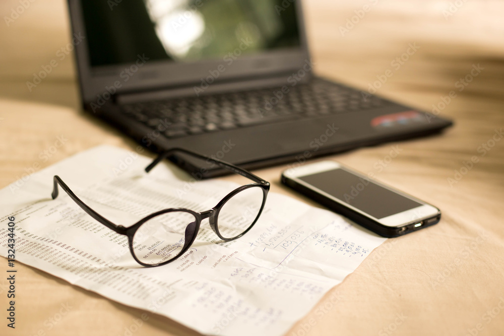Glasses with bank statement and cell phone Glasses with bank statement and cell phone