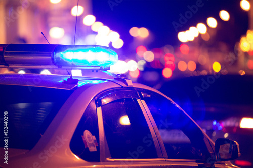 Niebieskie światło migacza na szczycie samochodu policyjnego Fototapeta