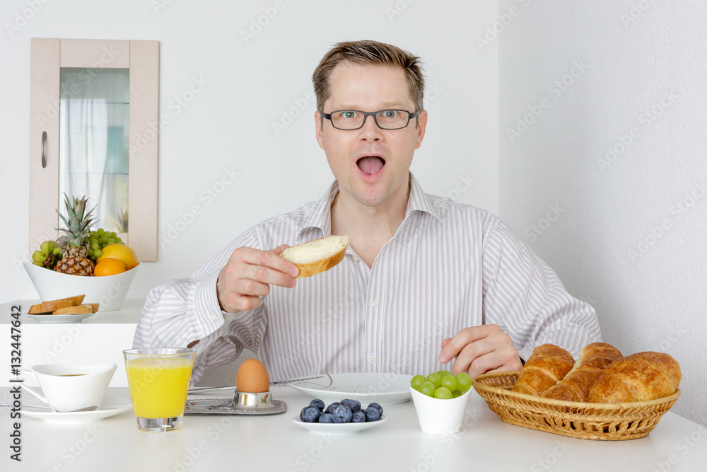 Mann schaut überrascht beim Frühstück Mann schaut überrascht beim Frühstück