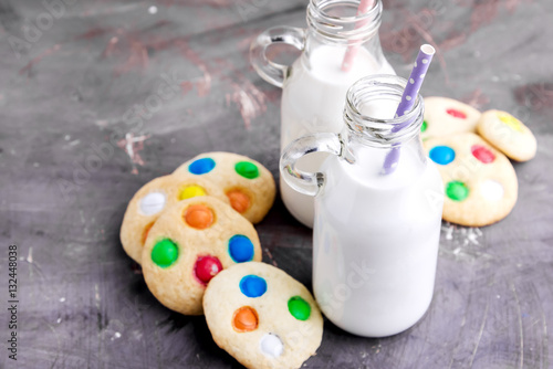 Two bottles of milk with straws and cookies
