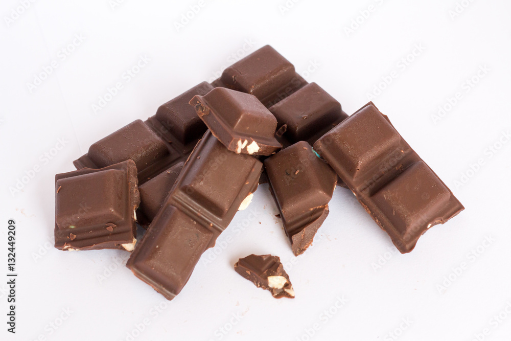 A few cubes of dark chocolate chunks pieces on white background A few cubes of dark chocolate chunks pieces on white background