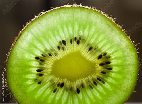 Slices of kiwi fruit on kiwi background.