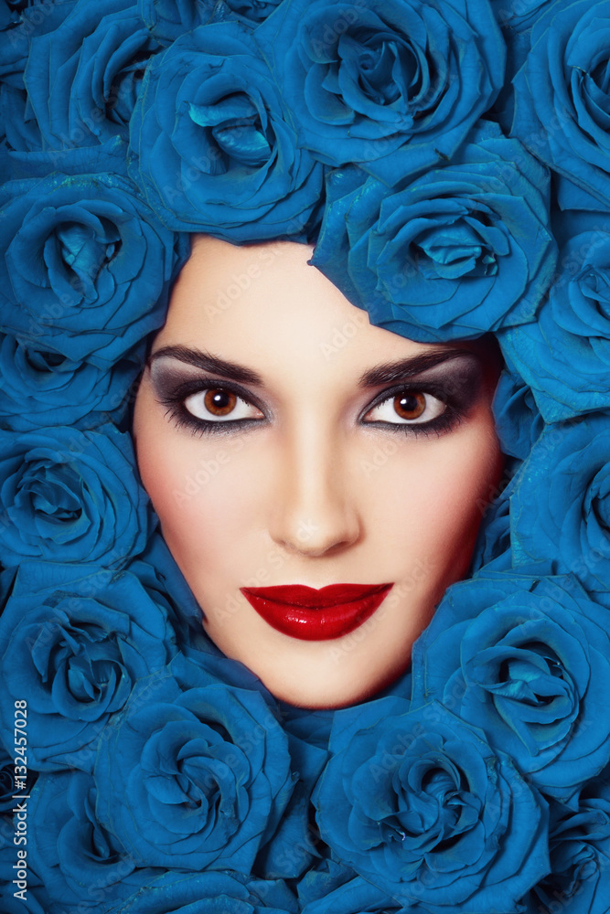 Vintage style close-up portrait of beautiful young girl with smoky eyes and blue roses around her face