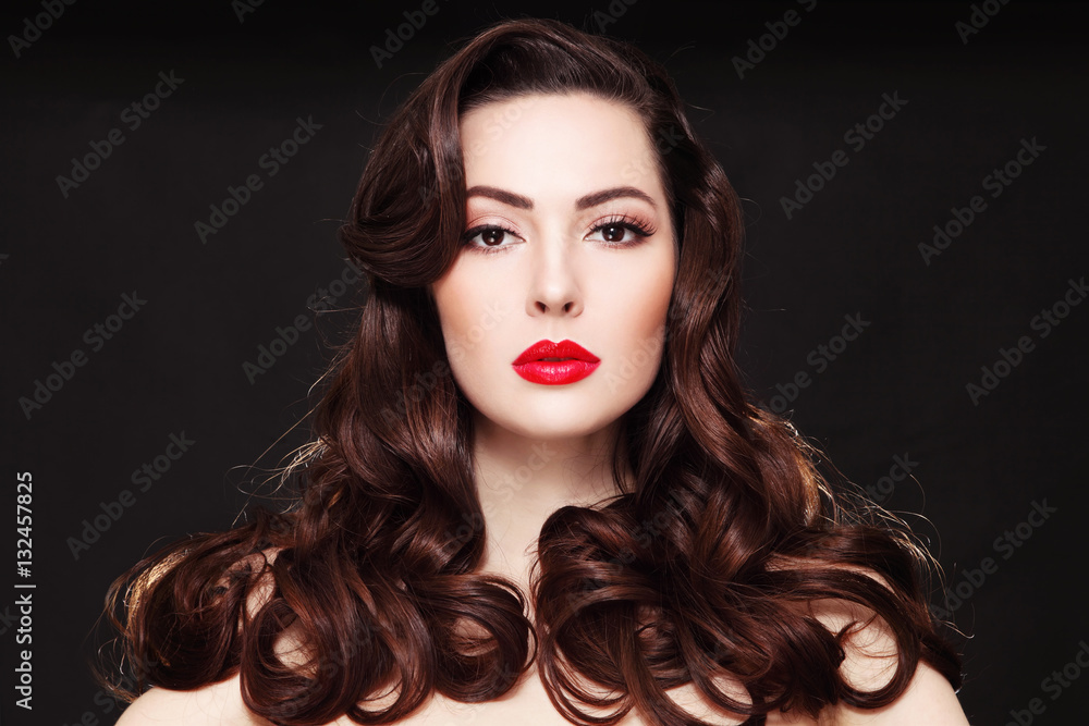 Obraz premium Portrait of young beautiful woman with long curly hair and red lipstick