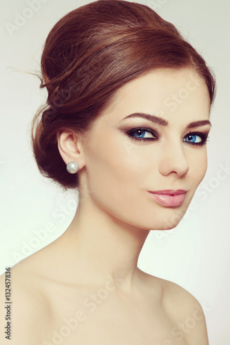 Vintage style portrait of young beautiful woman with stylish hair bun and smoky eyes