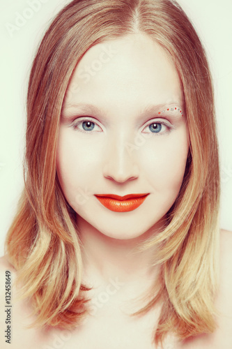 Vintage style portrait of young beautiful smiling blond girl with orange lipstick and fancy make-up