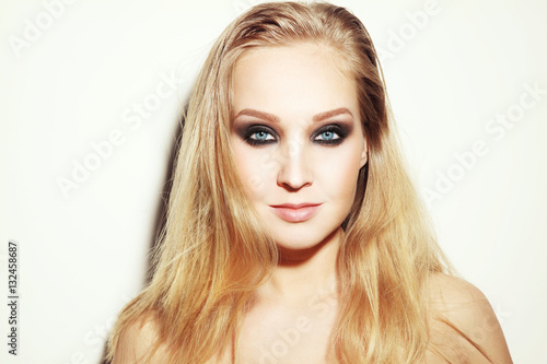 Vintage style horizontal portrait of young beautiful blond woman with long hair and smoky eyes