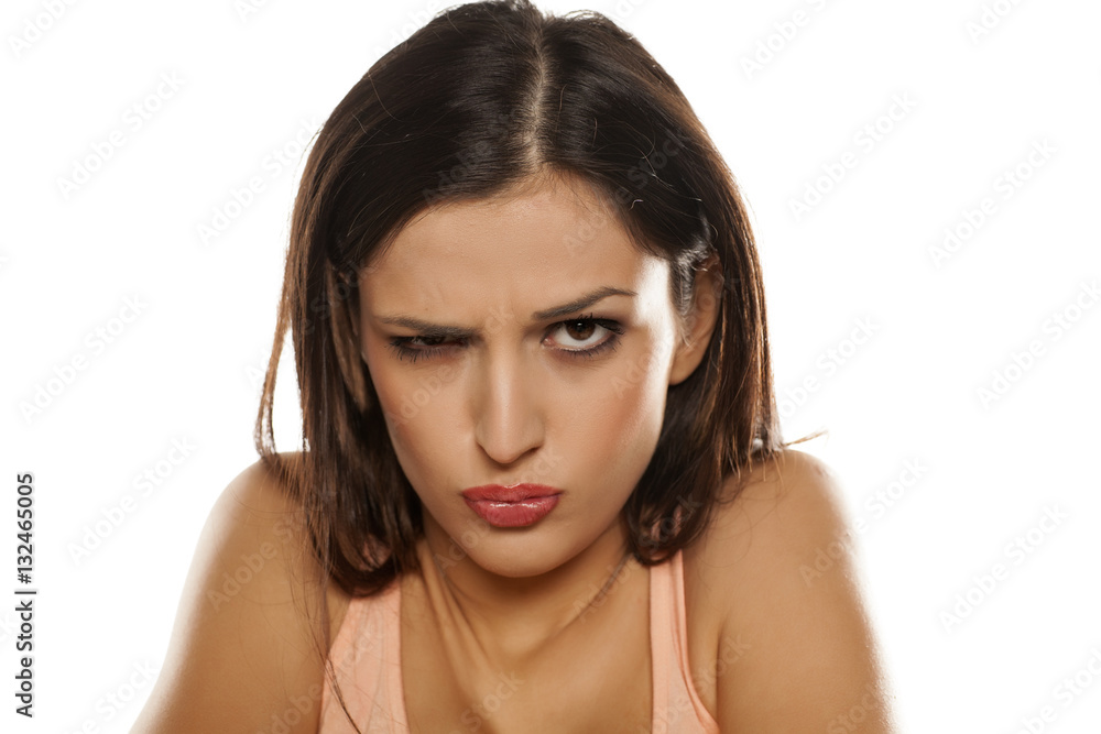scowling angry young woman on white background