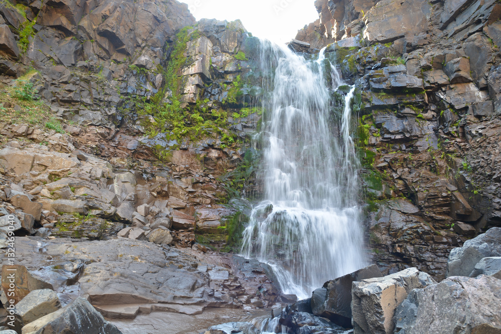 Obraz premium Waterfall among the rocks on the Putorana plateau.