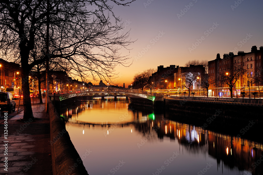 Ha'penny Bridge and the north banks of the river Liffey in Dublin City Centre at night. Ha'penny Bridge is a pedestrian bridge built in 1816 of cast iron