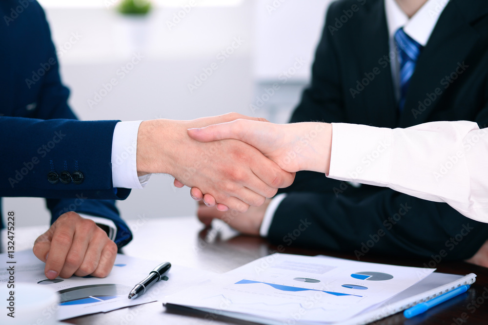 Business people shaking hands finishing up a meeting Business people shaking hands finishing up a meeting