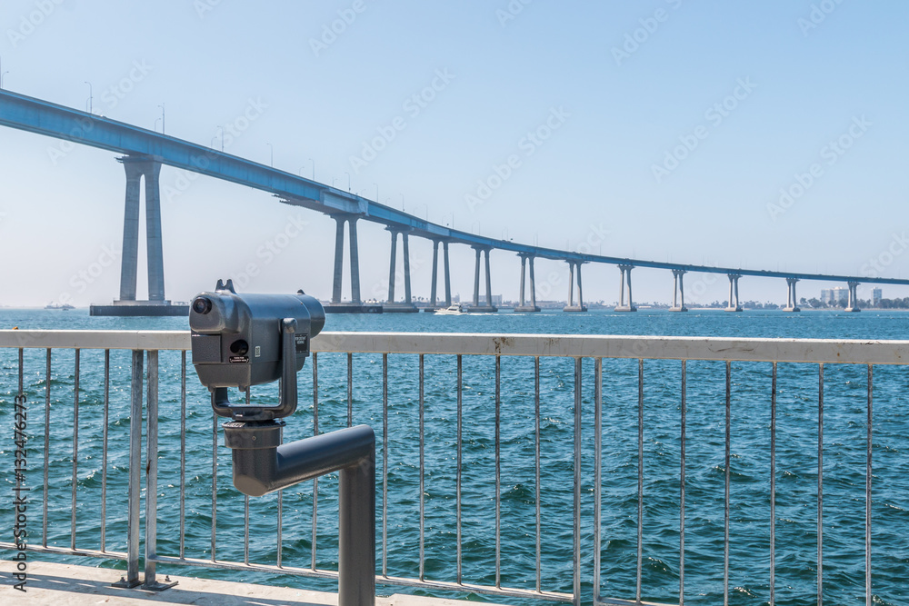 Sightseeing binoculars facing the Coronado bridge in San Diego, California, on a viewing pier at Cesar Chavez Park.