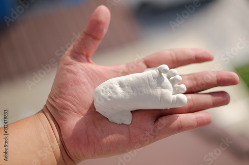 Plaster baby feet on hand