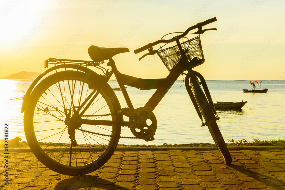 Ride a bicycle on beach with warm light background Ride a bicycle on beach with warm light background