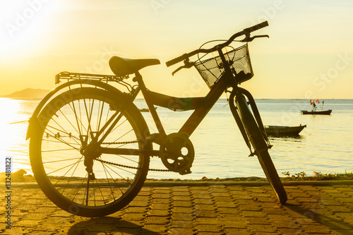Ride a bicycle on beach with warm light background