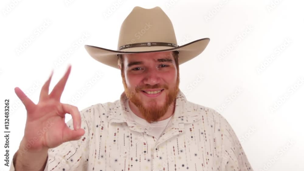 Hipster millennial cowboy putting on his cowboy hat and smiling Hipster millennial cowboy putting on his cowboy hat and smiling