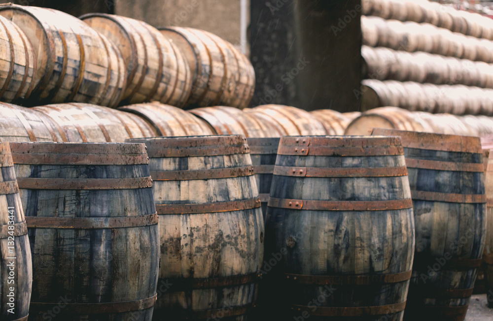 Old vintage whisky barrels filled of whiskey placed in order in