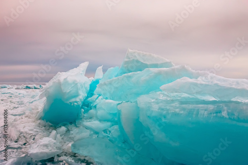 Arctic blue glacier ice hummock in cloudy weather © Baikal360