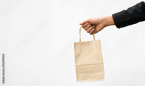 Brown Bag,Hand holding a paper bag isolated on white background. Delivery concept 