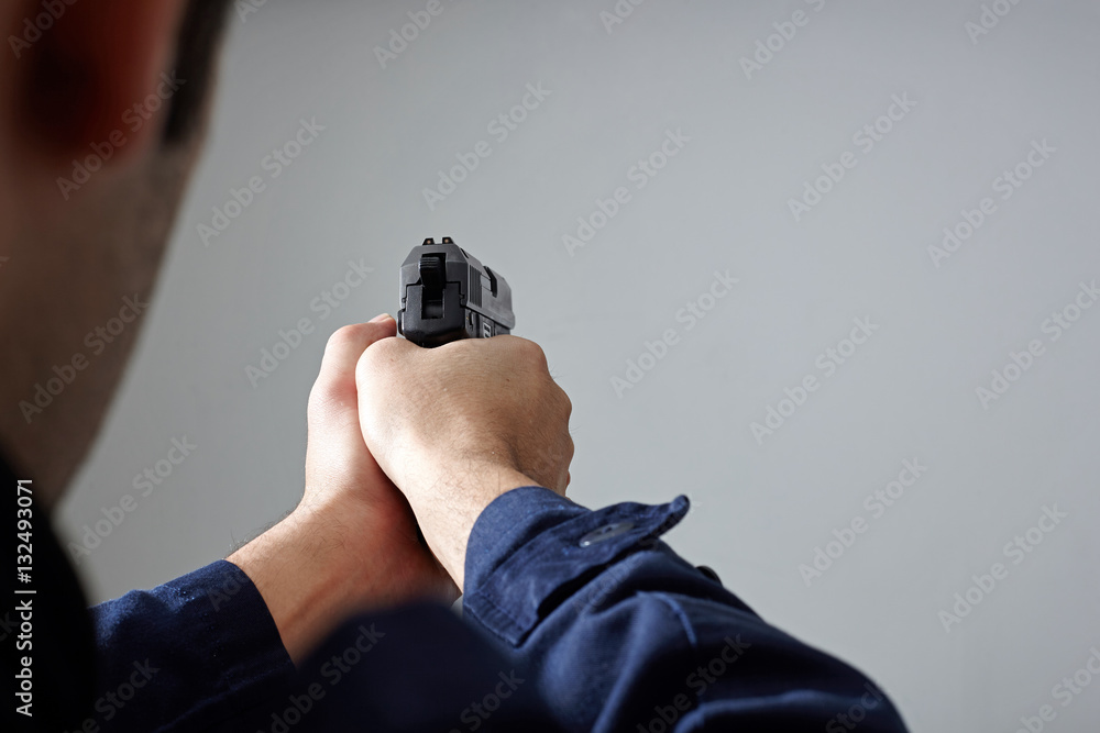 Fototapeta premium Police officer's hands aiming with gun.