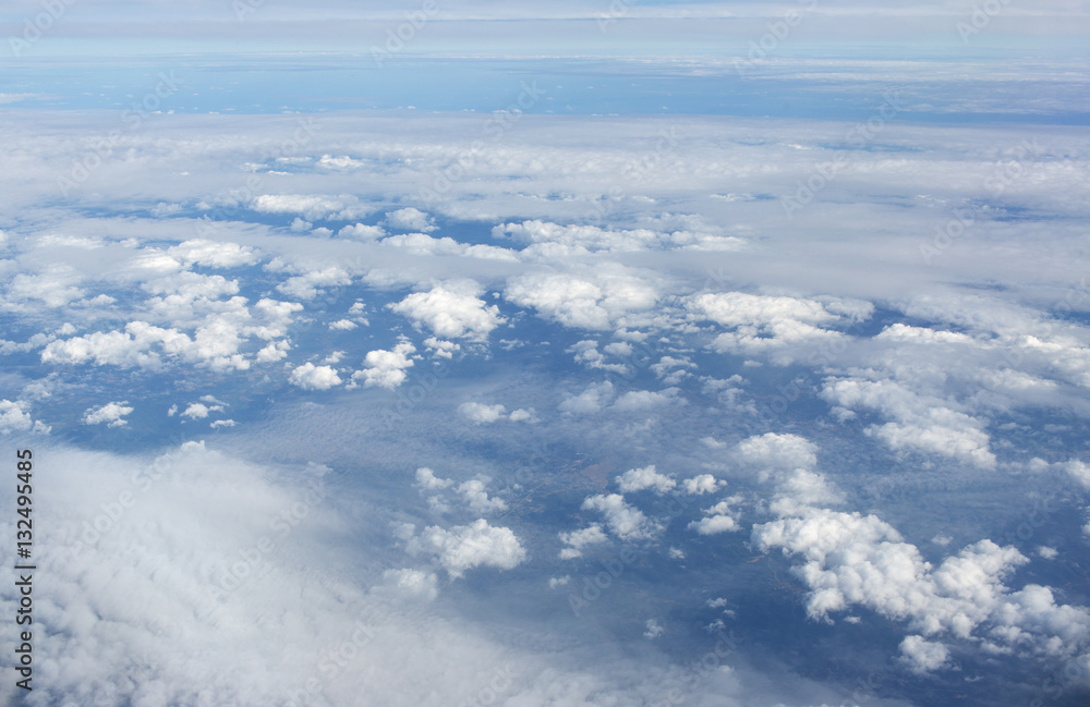 Aerial view on clouds and blue sky from airplane window