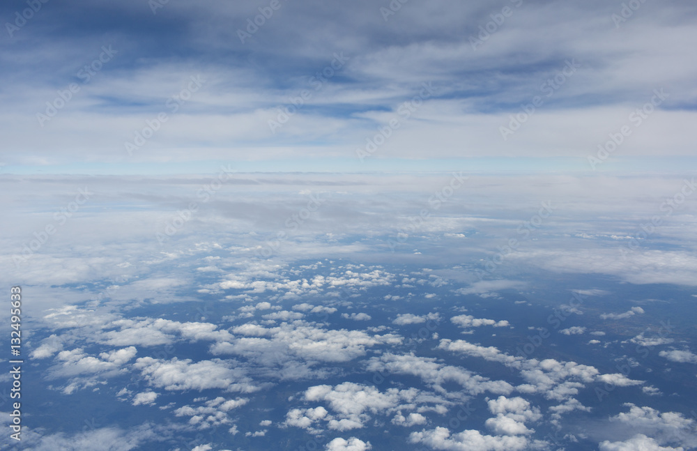 Aerial view on clouds and blue sky from airplane window Aerial view on clouds and blue sky from airplane window