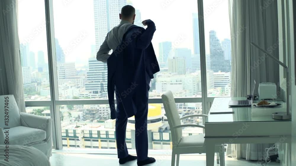 Businessman putting on jacket standing by window at home, super slow motion 240fps
Businessman putting on jacket standing by window at home, super slow motion 240fps
