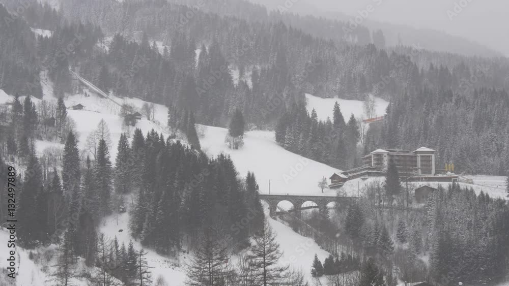 Typical winter landscape in the Austrian Alps with snowfall and blizzard Typical winter landscape in the Austrian Alps with snowfall and blizzard