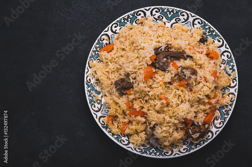 Pilaf on plate with oriental ornament. Central-Asian cuisine - Plov. Top view.