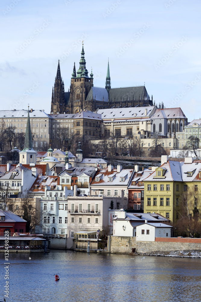 Obraz premium Snowy freeze Prague Lesser Town with gothic Castle above River Vltava, Czech republic