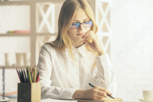 Attractive woman writing in notepad