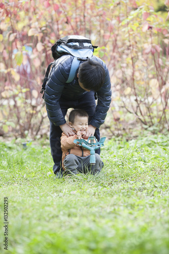 Happy real father and son playing in meadow
