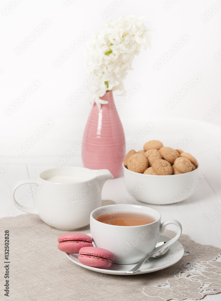 Hyacinth Flowers In Vase. Amaretti Biscuits. Cup Of Tea