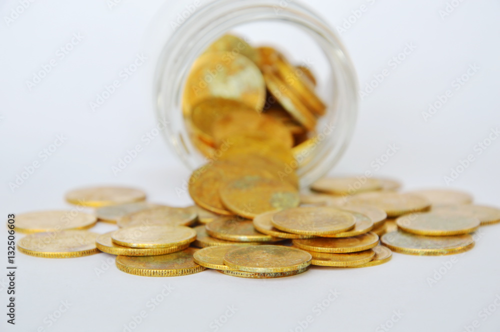 gold coin pour from glass bottle on white background gold coin pour from glass bottle on white background