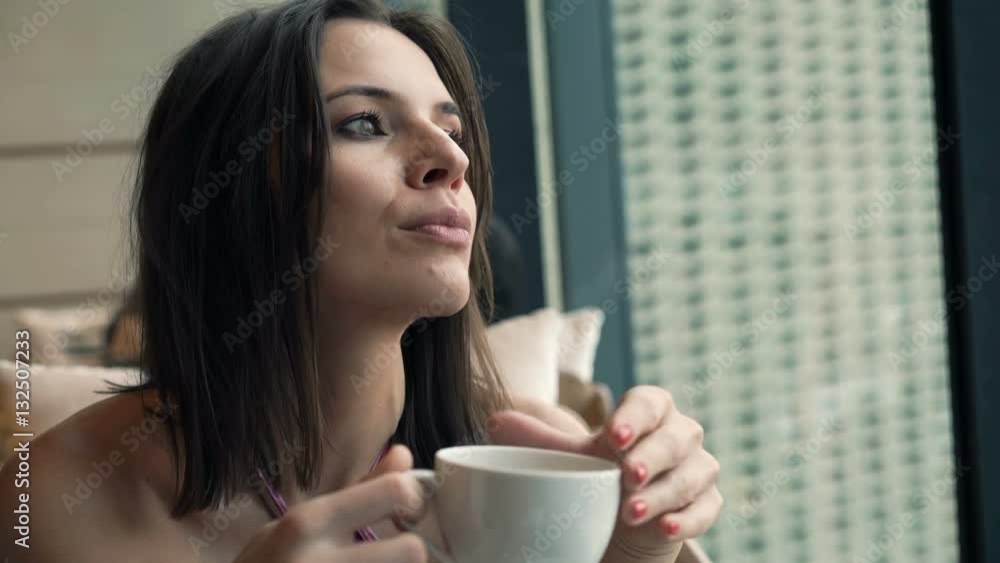 Young, pensive woman drinking coffee sitting in cafe
Young, pensive woman drinking coffee sitting in cafe