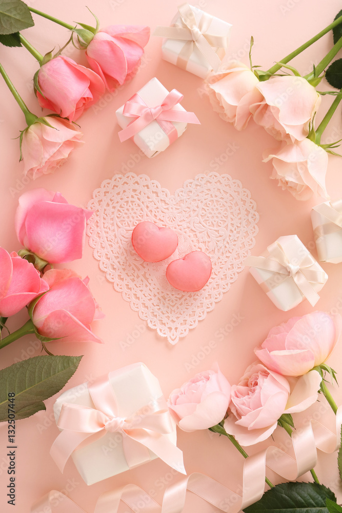Pink macaroons with beautiful pink tone roses and gift boxes on pastel pink background,top view Pink macaroons with beautiful pink tone roses and gift boxes on pastel pink background,top view