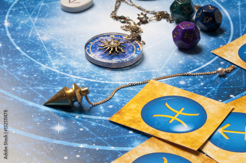  oracle esoteric concept with pendulum, zodiac signs, and astrology cubes,  photo