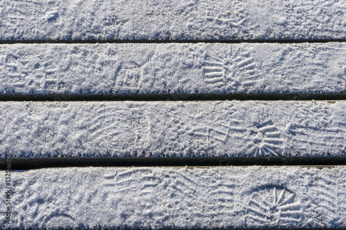 Spuren im Schnee auf Holzbrettern