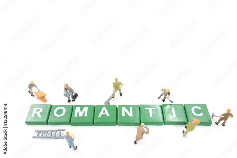 Miniature worker team building word romantic on white background