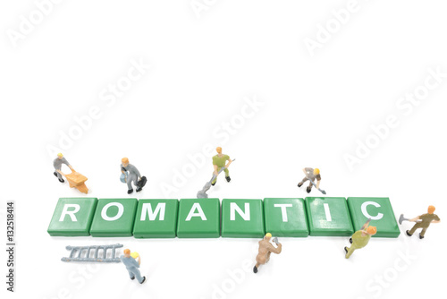 Miniature worker team building word romantic on white background