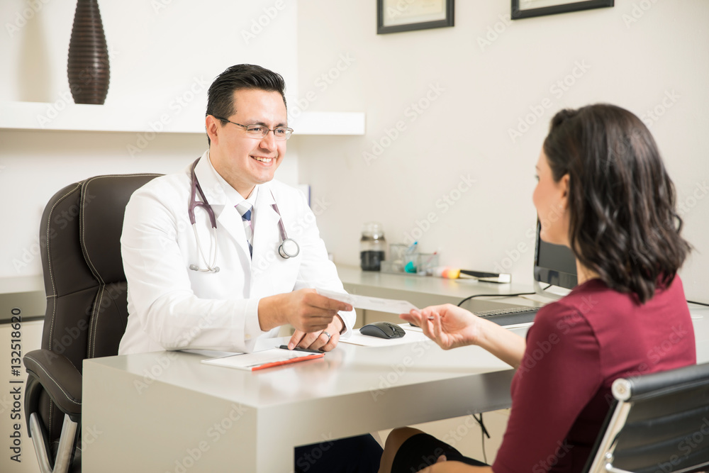 Doctor handing medical prescription to patient Doctor handing medical prescription to patient