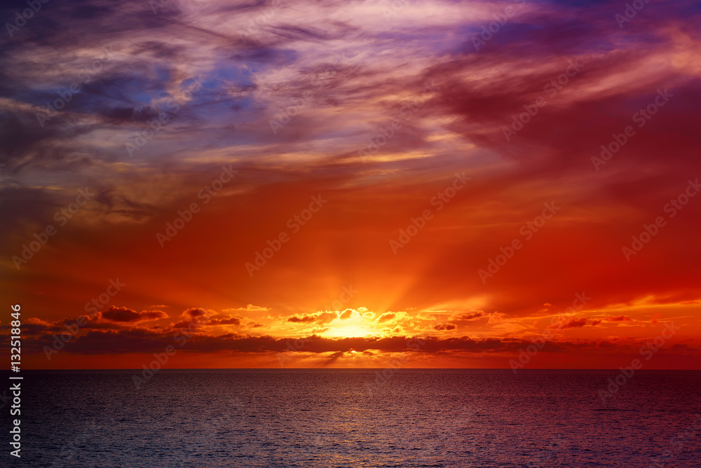 Beautiful colorful sunset at the sea with dramatic clouds and sun shining. Beauty world natural outdoors travel background