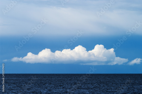 Blue sky with white cumulus cloud over the Baltic sea. Pomerania, Poland.