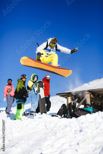 Jumping snowboarder on blue sky background