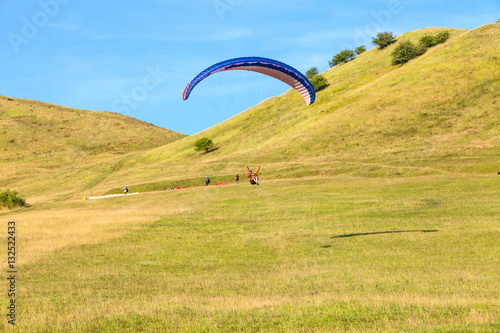 Paraglider over the green valley 