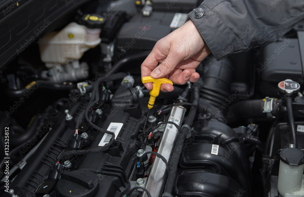 A man are checking engine oil level A man are checking engine oil level