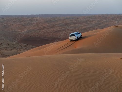 Mittlerer Osten , Arabien, Sultanat Oman,Al Raka, ein Geländefahrzeug steht in den Sanddünen der Wüste Rimal Al Wahiba oder Wahiba Sands, auch Ramlat al-Wahiba oder Scharqiyya Sands, im Abendlicht