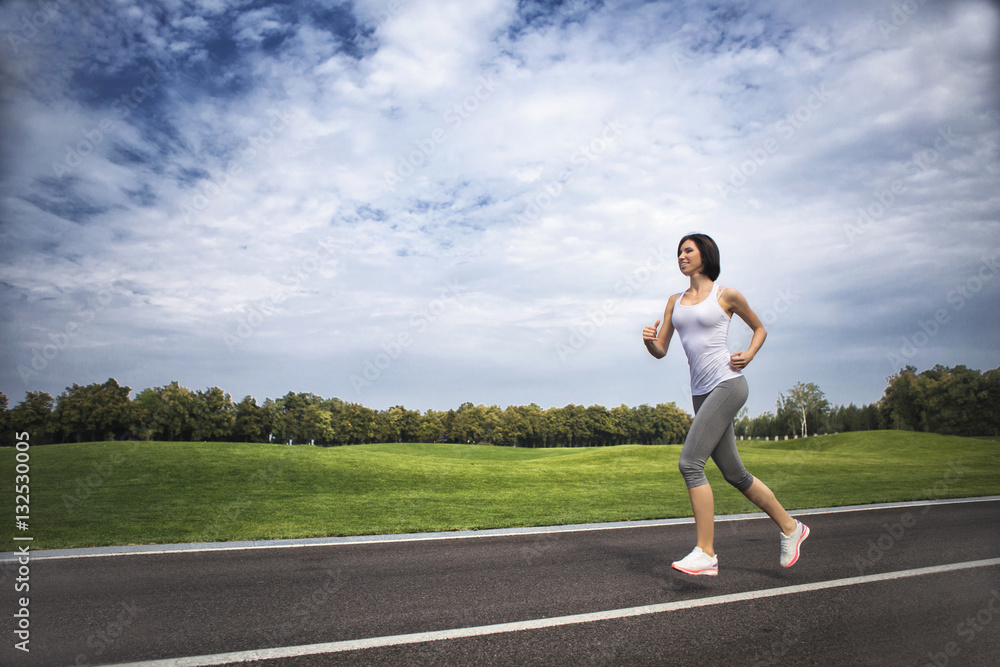 Young woman runs on an empty road . Morning Exercise Young woman runs on an empty road . Morning Exercise