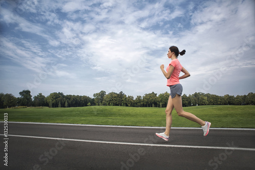 Young woman runs on an empty road . Morning Exercise