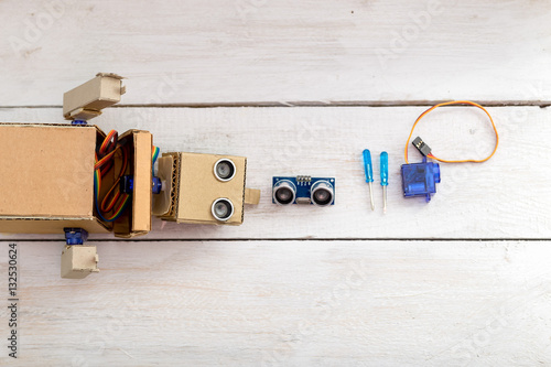 robot  screwdrivers and servomotrchiki on a wooden white table.